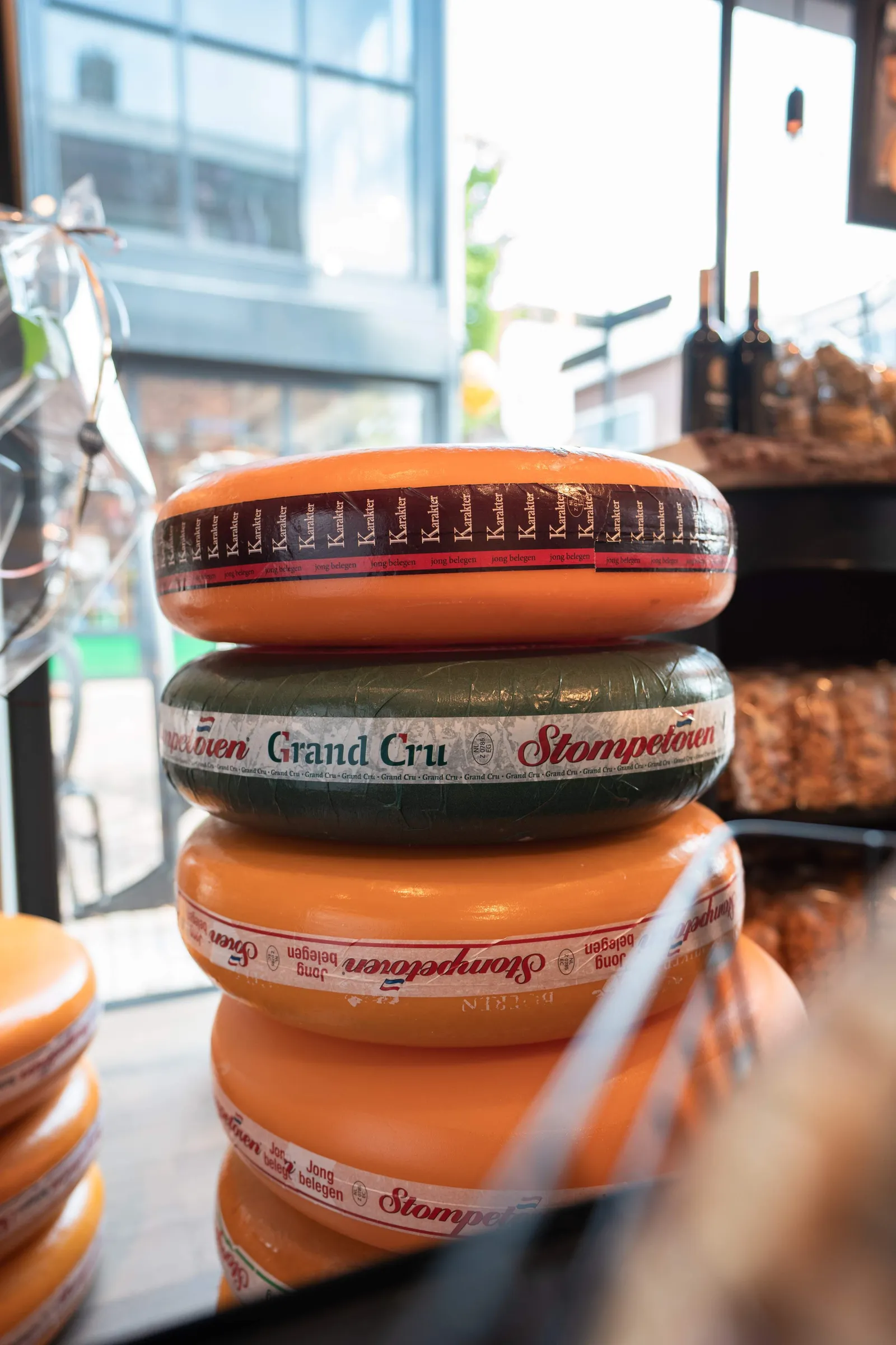 Stapel kaaswielen Karakter en Stompetoren Grand Cru bij het raam